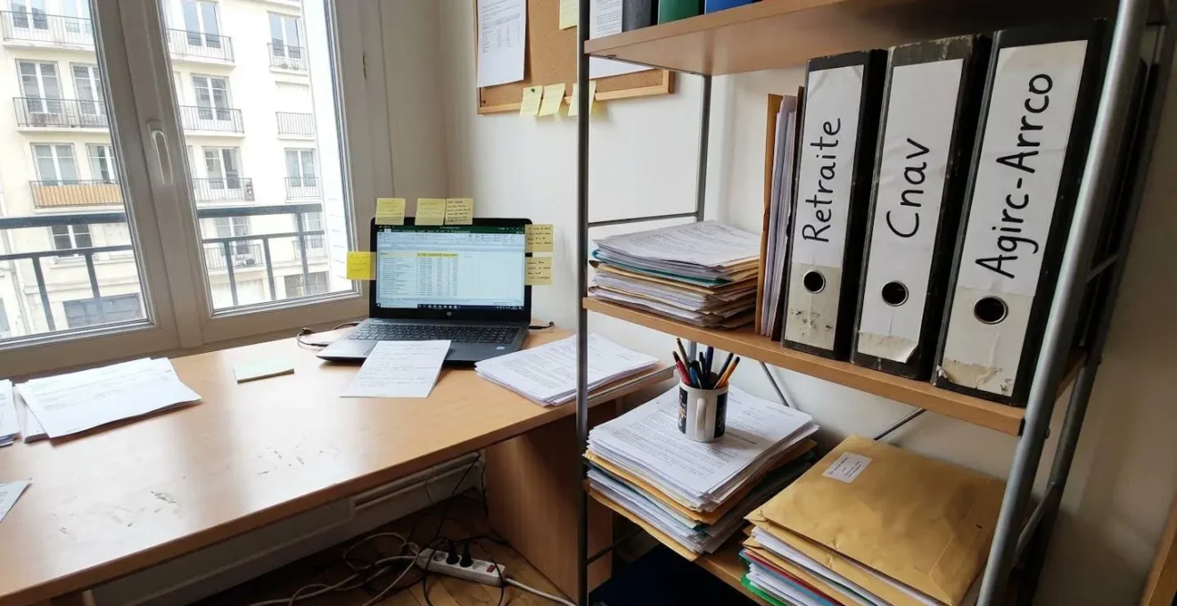 Bureau à domicile organisé avec classeurs de documents retraite étiquetés rangés sur une étagère